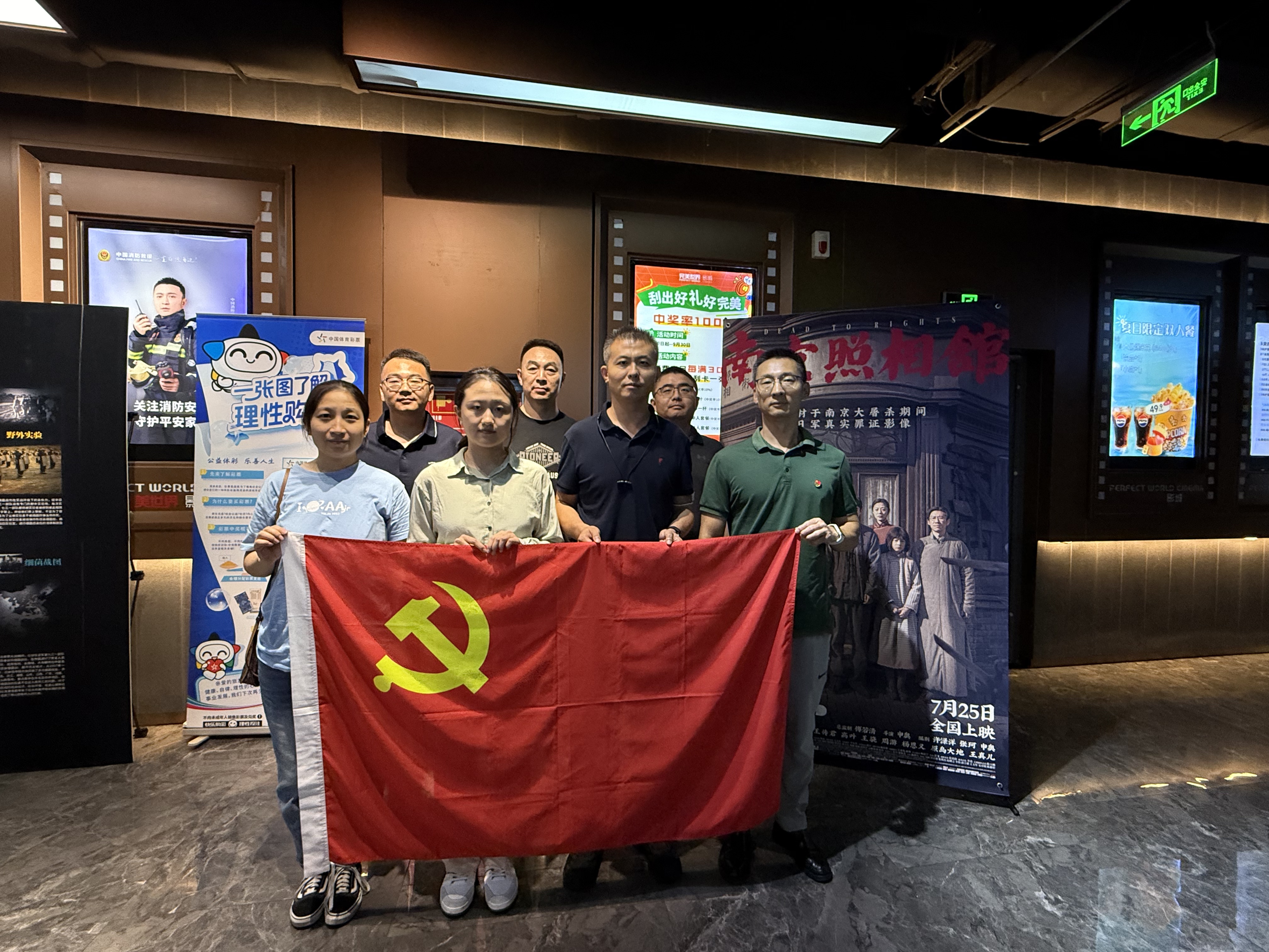 党员同志在《南京照相馆》海报前合影(1).jpg